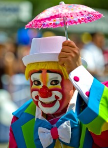 A clown poses for a photograph with a no